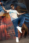 Man wearing a blue den knit regular denim jogger in ice blue with casual styling on a gray background