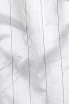 Close-up of white fabric with subtle texture and stitching details