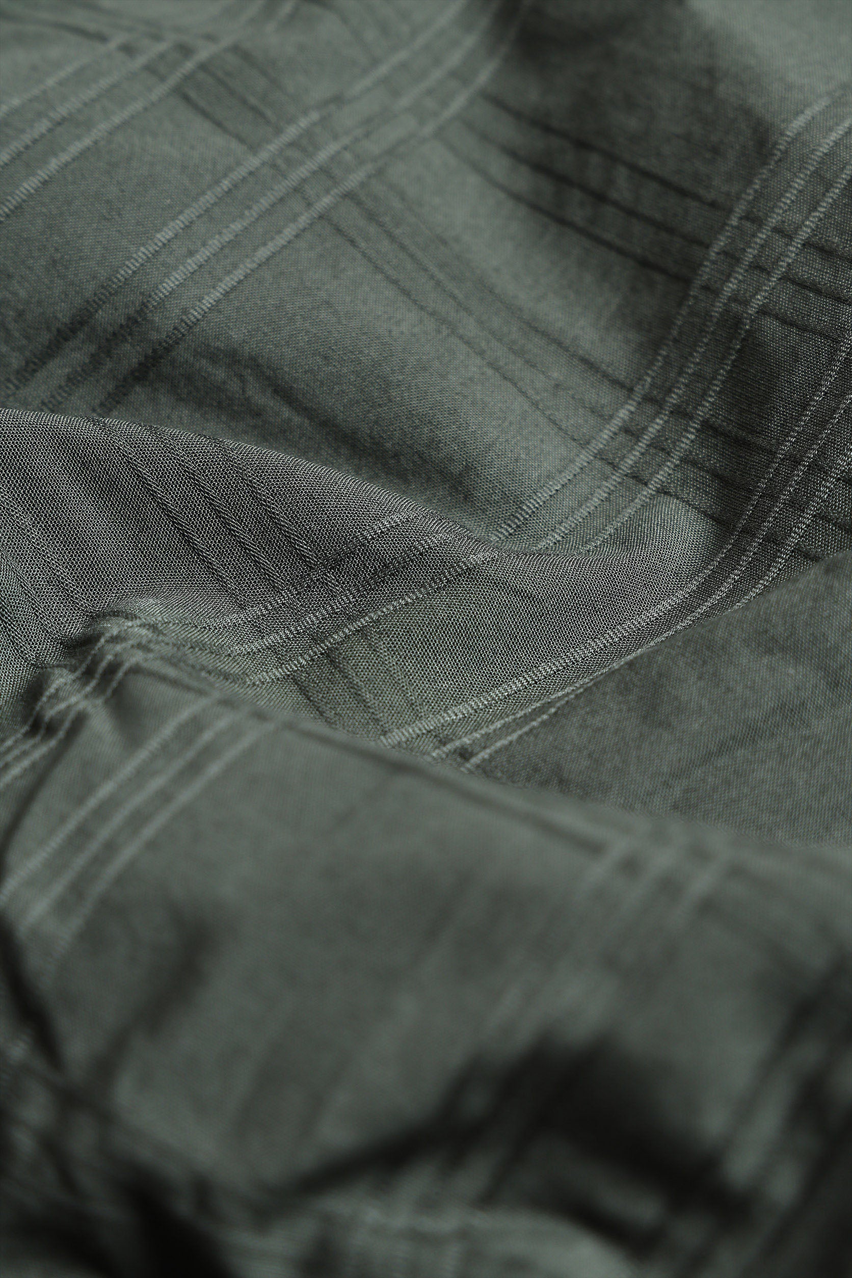 Close-up of green fabric with visible texture and stitching