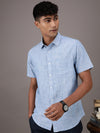 Man wearing a blue light blue solid half sleeve 100% cotton shirt on a light gray background