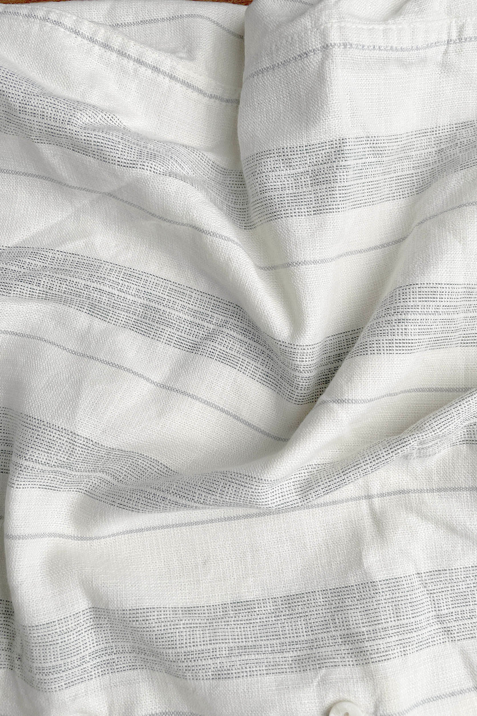 Close-up of white fabric with subtle gray stripes