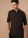 Man wearing a green olive green checked full sleeve 100% cotton shirt on a light gray background