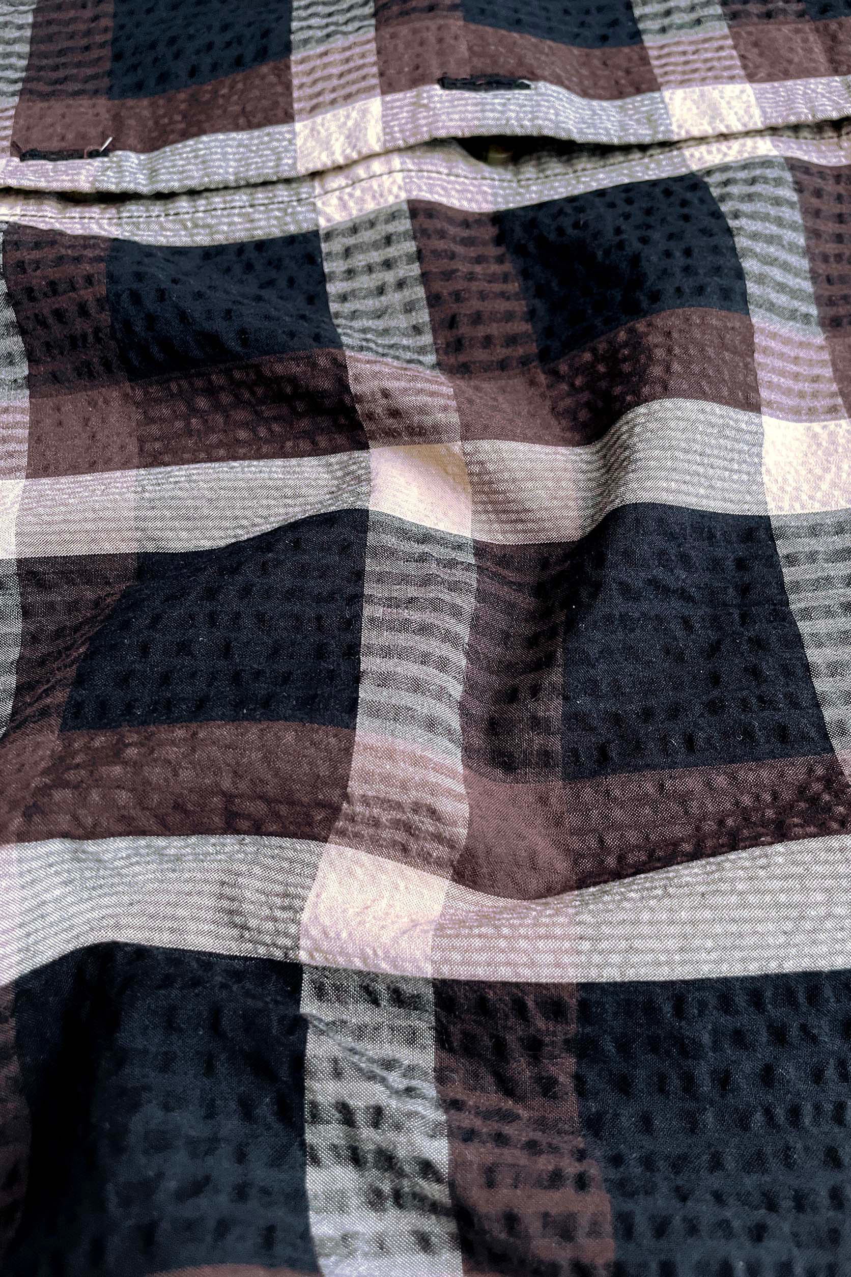 Close-up of checkered fabric with brown, black, and white pattern