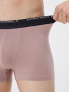 Person wearing pink shorts with a black Crocodile brand belt on a white background