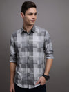 Man wearing a grey grey checked full sleeve 100% cotton shirt with casual styling on a gray background