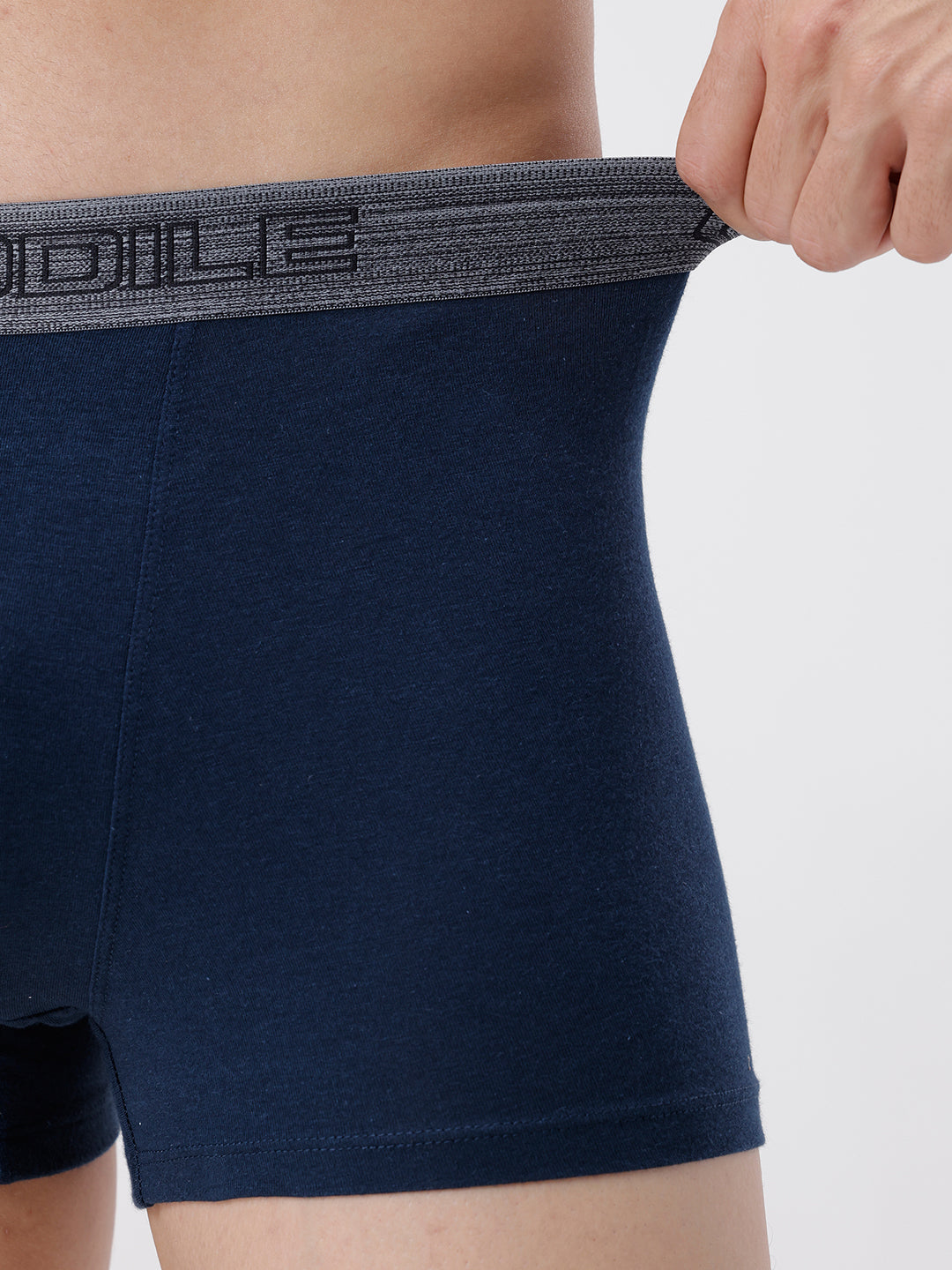 Navy blue boxer briefs with a brand logo on the waistband against a light gray background