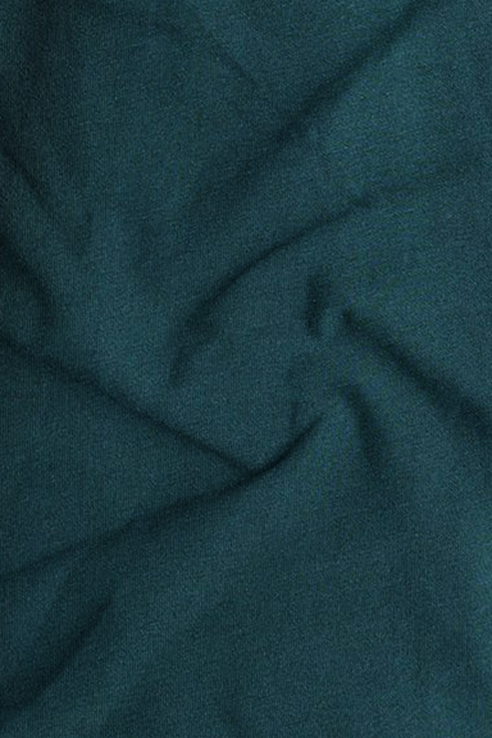Close-up of teal fabric with folds