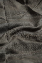 Close-up of textured dark green fabric with a subtle pattern