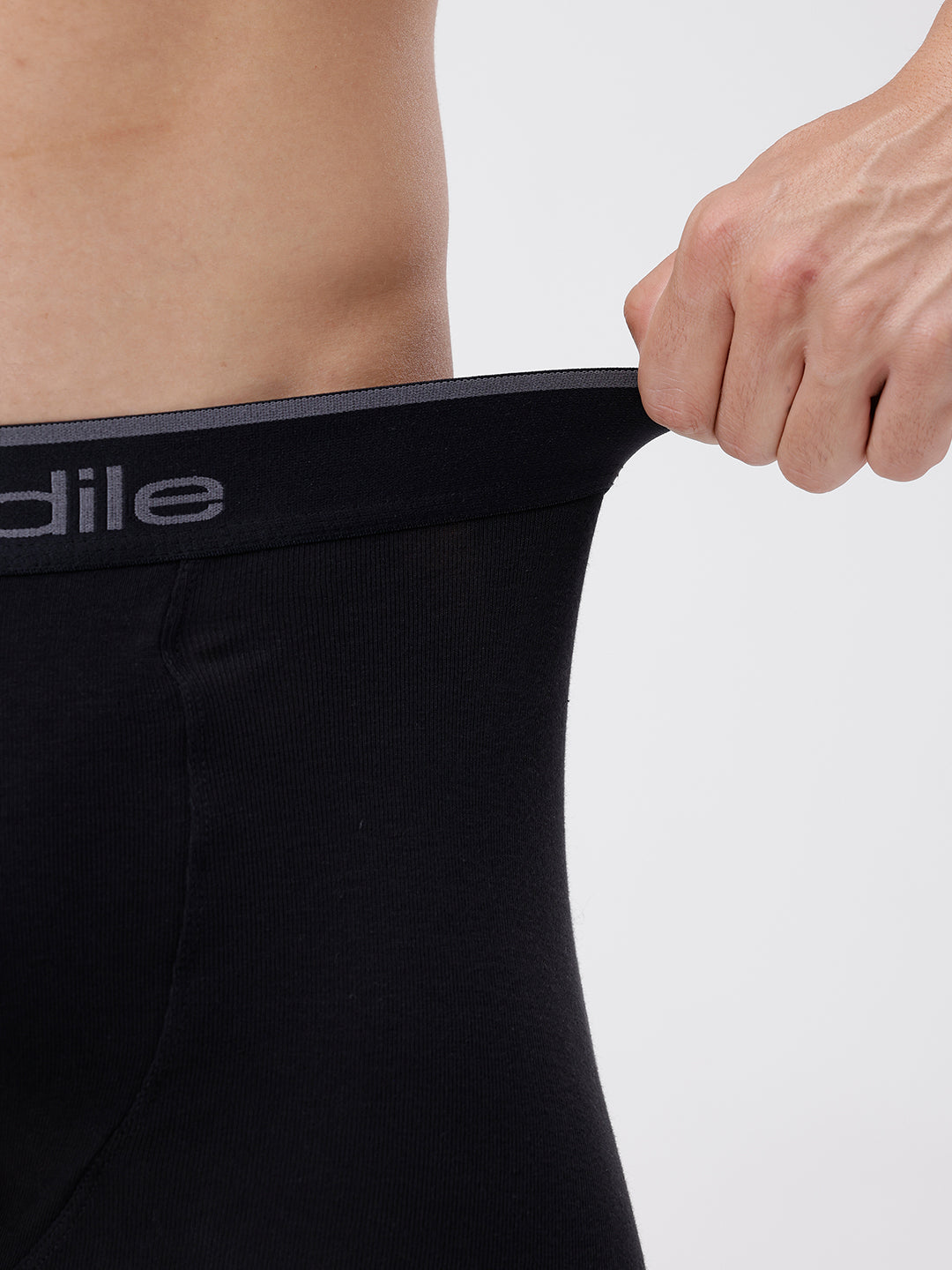 Person holding a black athletic shirt with 'Adile' branding on a white background