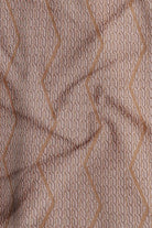 Close-up of a textured fabric with wavy lines in brown tones.