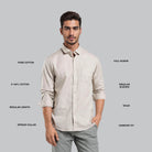 Man wearing a beige shirt with text describing its features on a gray background