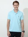 Man wearing a blue blue solid half sleeve casual polo t shirt with casual styling on a gray background