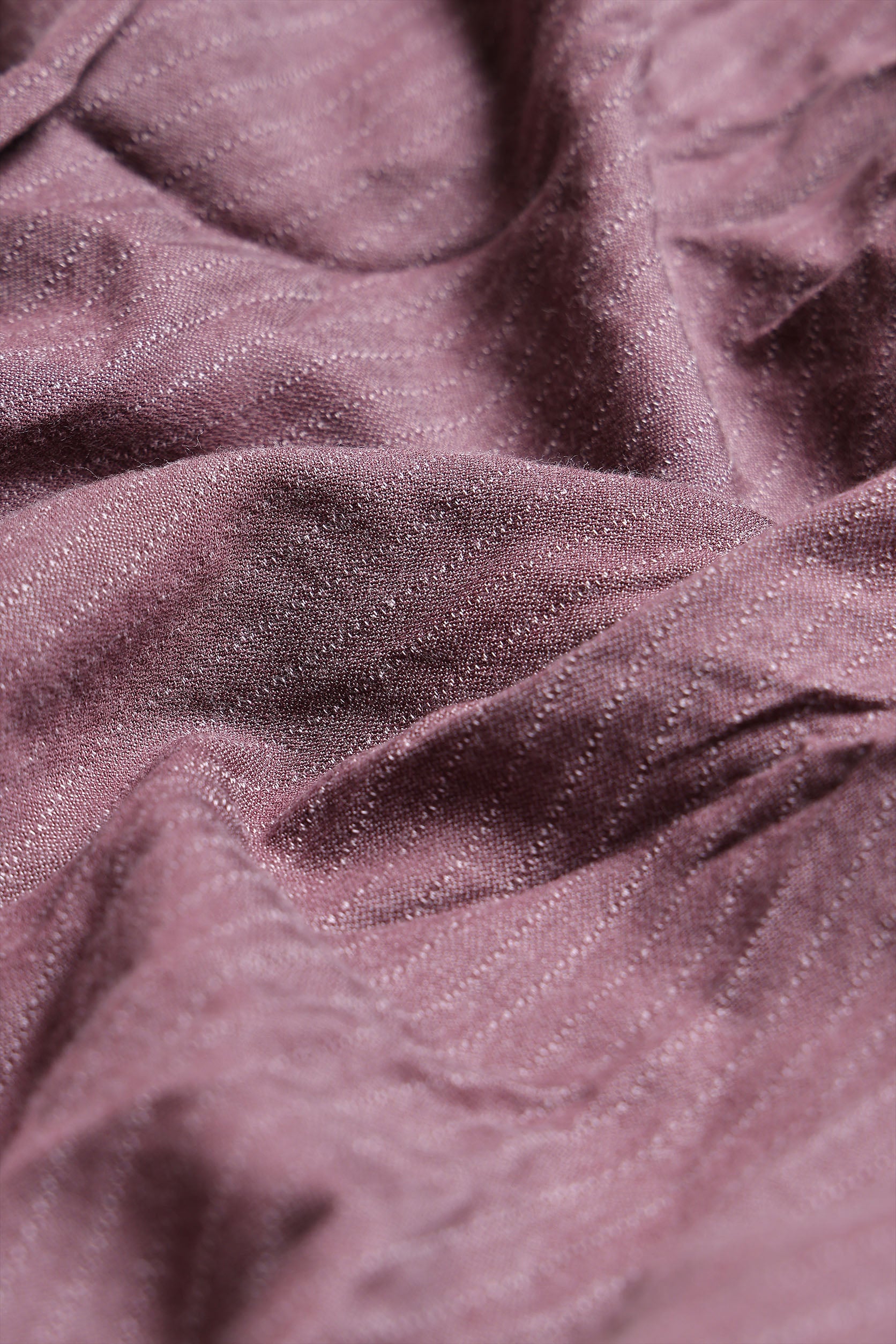 Close-up of textured purple fabric with a soft sheen