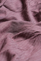 Close-up of textured purple fabric with a soft sheen
