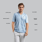 Man wearing a light blue patterned polo shirt with text labels on a gray background
