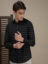 Man wearing a black black checked full sleeve shirt with casual styling on a gray background