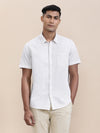 Man wearing a beige breezy beige printed half sleeve shirt with casual styling on a gray background