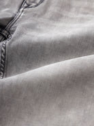 Man wearing a grey light grey knit slim fit jeans on a light gray background