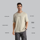 Man wearing a beige t-shirt with text on a gray background