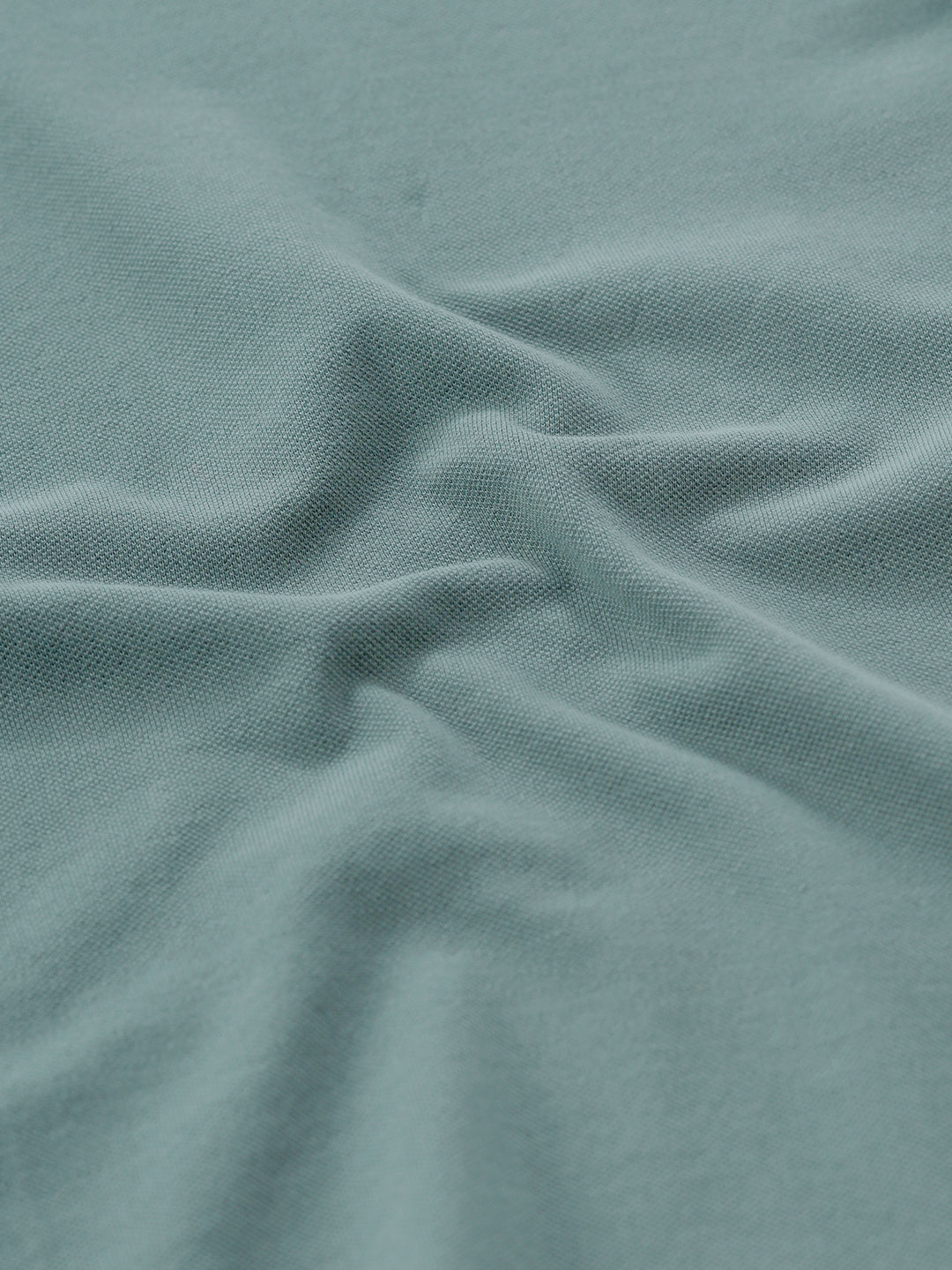 Man wearing a green iceberg green chest print slim fit polo t shirt on a light gray background