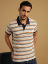 Man wearing a blue blue casual striped polo t shirt with pocket on a light gray background