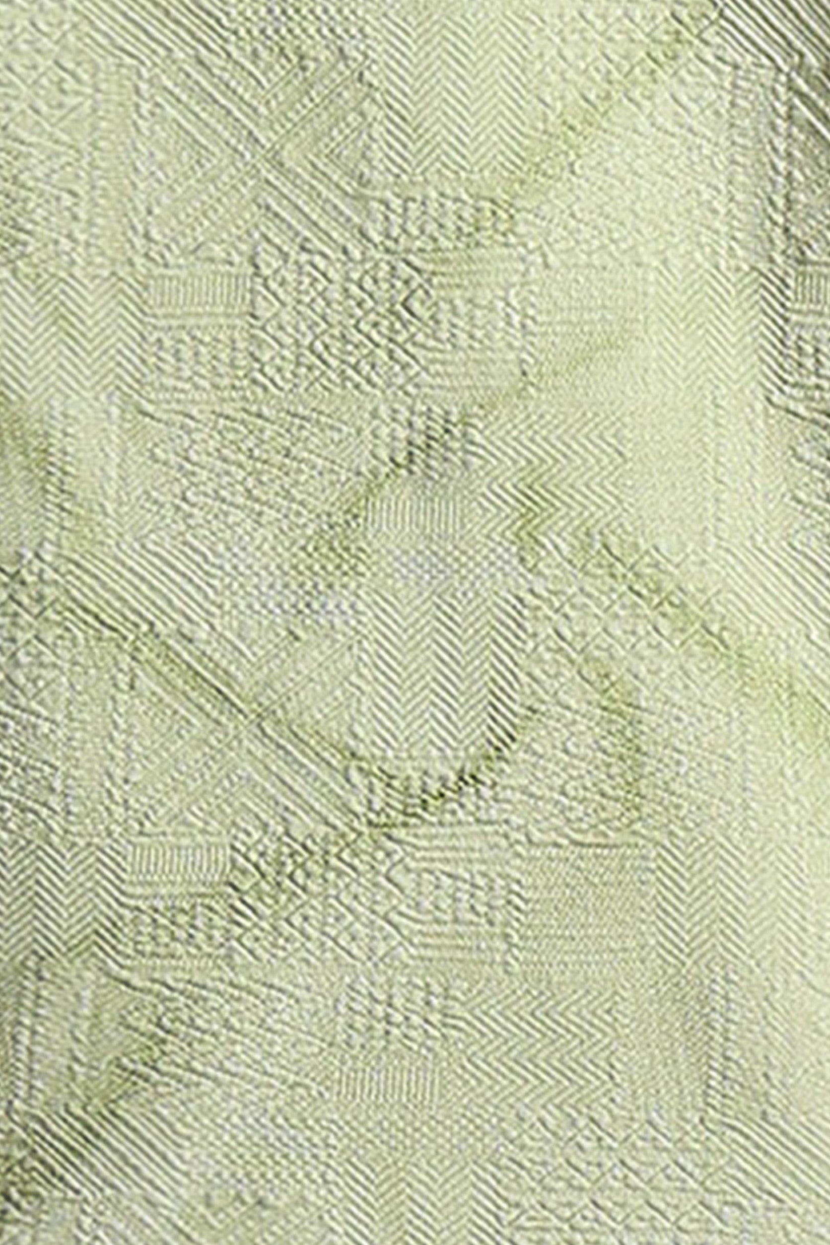 Close-up of a textured light green fabric with a subtle pattern