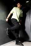 Man wearing a black den knit regular denim jogger in jet black with casual styling on a gray background