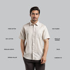 Man wearing a beige shirt with text describing its features on a gray background
