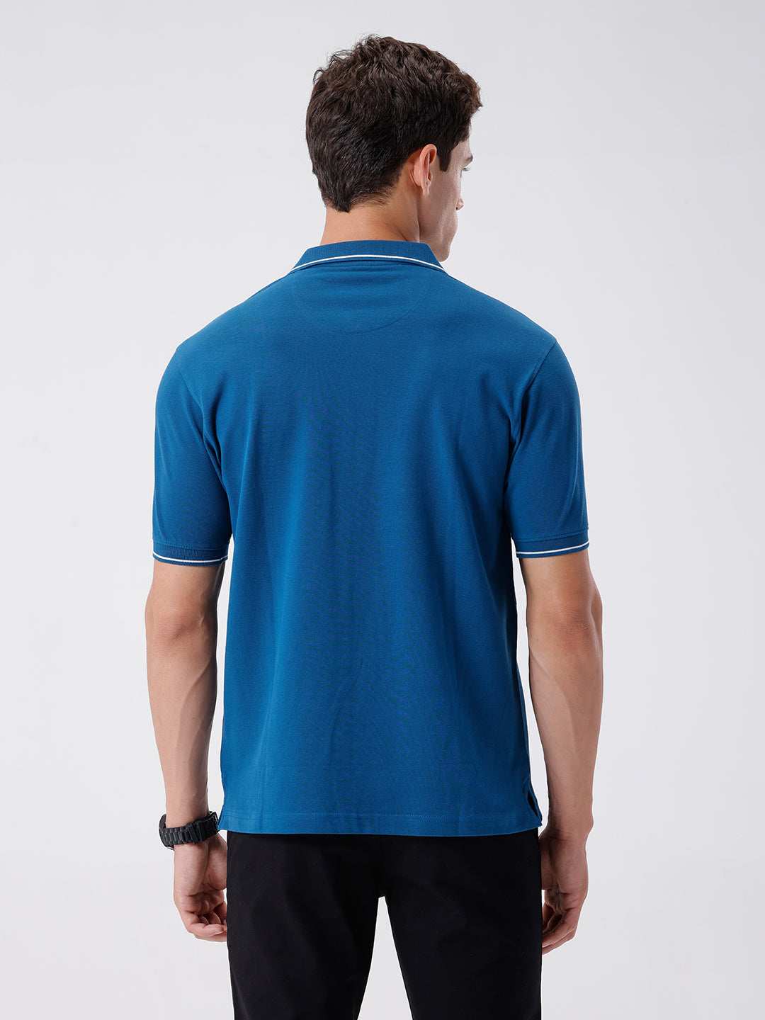 Man wearing a green iceberg green chest print slim fit polo t shirt on a light gray background