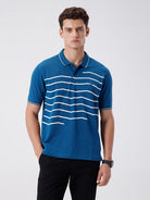 Man wearing a green iceberg green chest print slim fit polo t shirt on a light gray background