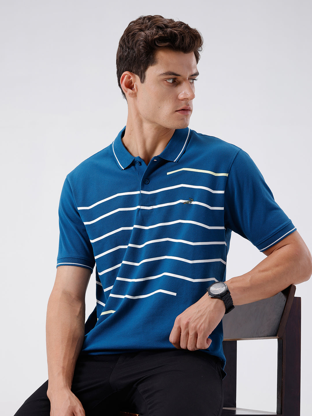 Man wearing a green iceberg green chest print slim fit polo t shirt on a light gray background