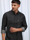 Man wearing a black casual black solid full sleeve 100% cotton shirt with casual styling on a gray background