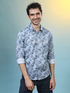 Man wearing a grey grey casual printed full sleeve 100% cotton shirt on a light gray background
