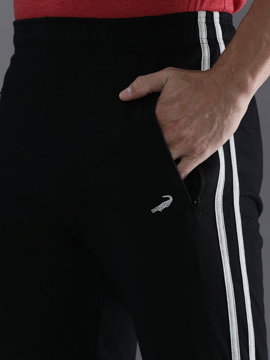 Black tracksuit with white stripes and a logo on a dark background