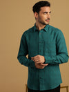 Man wearing a green teal green checked full sleeve 100% cotton shirt on a light gray background