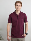 Man wearing a red solid red half sleeve casual polo t shirt on a light gray background
