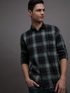 Man wearing a green checked full sleeve green 100% cotton casual shirt on a light gray background