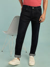 Man wearing a blue indigo blue solid mid rise slim fit jean on a light gray background