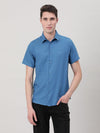 Man wearing a blue royal blue solid half sleeve linen shirt on a light gray background