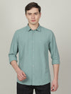Man wearing a blue solid full sleeve casual shirt blue with casual styling on a gray background