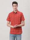 Man wearing a red brick red checked half sleeve shirt on a light gray background