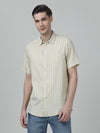 Man wearing a yellow light yellow checked half sleeve 100% cotton shirt on a light gray background