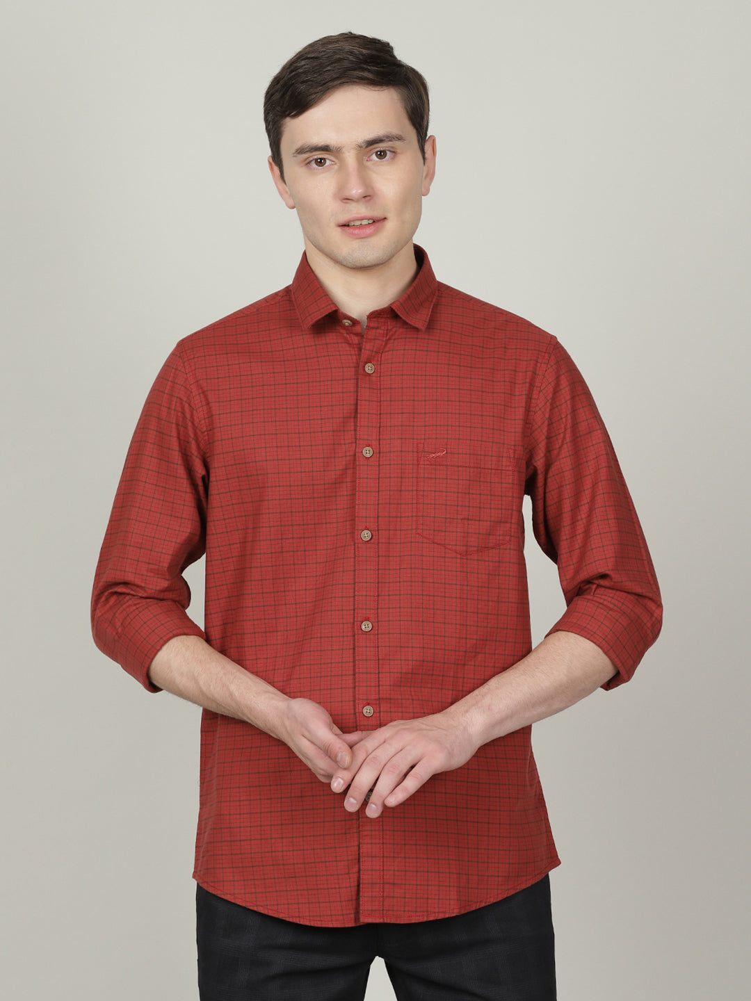 Man wearing a brown rust brown checked full sleeve 100% cotton casual shirt with casual styling on a gray background