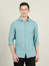 Man wearing a green green solid full sleeve linen shirt on a light gray background