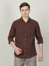 Man wearing a brown brown checked casual full sleeve 100% cotton shirt with casual styling on a gray background